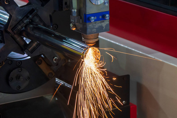 La machine de découpe laser à fibre a coupé le tube métallique. Le procédé de fabrication de tôles de haute technologie par machine de découpe laser.  - Photo, image