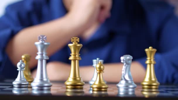Close up of hands of a businessman moving king golden chess to surrender with an opponent the chess game is development analysis, strategy, and plan, the management or leadership concept. - Footage, Video