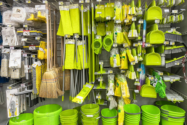 Tools for cleaning in the store. Shopping with background of green equipments on shelf in shop. - Photo, Image