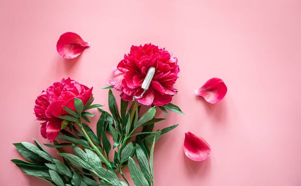 Plato plano, tampón y flor sobre fondo rosa, la menstruación y el concepto de salud de las mujeres. - Foto, Imagen