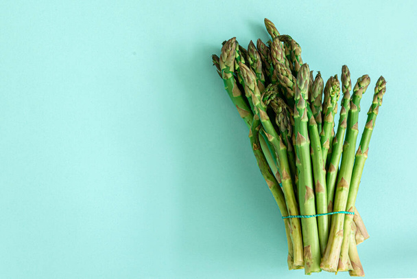 Fresh sliced asparagus plant on blue background. Top view. Vegan healthy food. - Photo, image