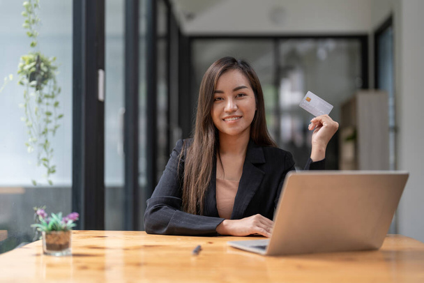 Jeune femme asiatique faisant ordinateur portable pour les services bancaires mobiles, l'achat en ligne achats avec carte de crédit - Photo, image