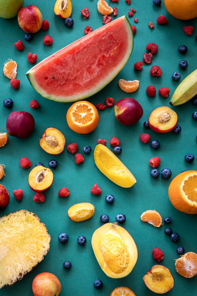 Tropical fruits and berries on a blue background, flat lay. - Valokuva, kuva