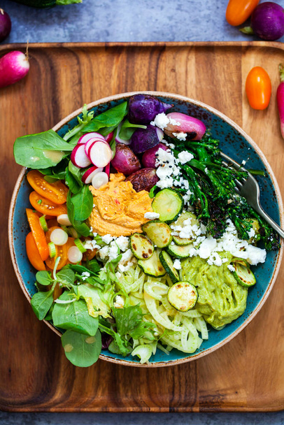 Buddha bowl with mixed roast and raw vegetables, guacamole, hummus and miso dressing - Photo, Image