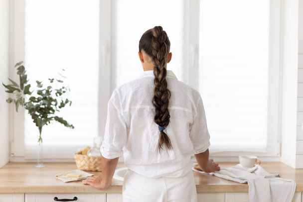 Giovane donna pulisce la cucina con prodotti ecologici - Foto, immagini