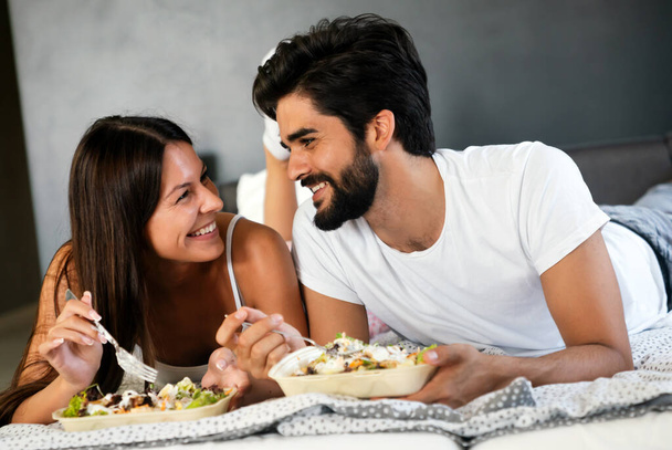 Romantic happy couple having breakfast in bed at home - Photo, Image
