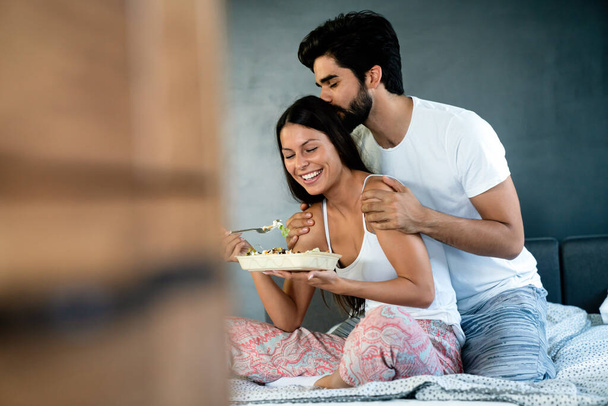 Romantic happy couple having breakfast in bed. Love, people, food concept - Photo, image