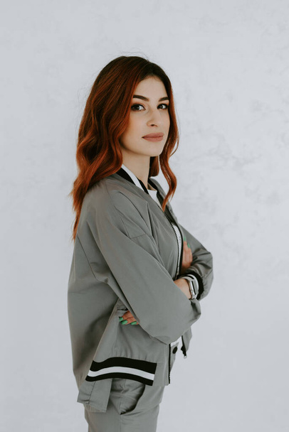 hübsche Geschäftsfrau im grauen Anzug mit Tablet auf weißem Hintergrund - Foto, Bild
