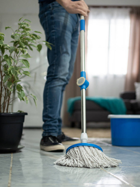 Man mopping floor at home. No face shown. Vertical - Foto, afbeelding