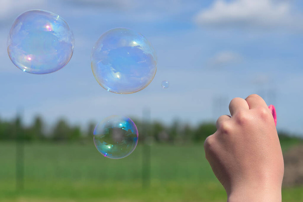 The child blows soap bubbles in nature. close up - Фото, зображення