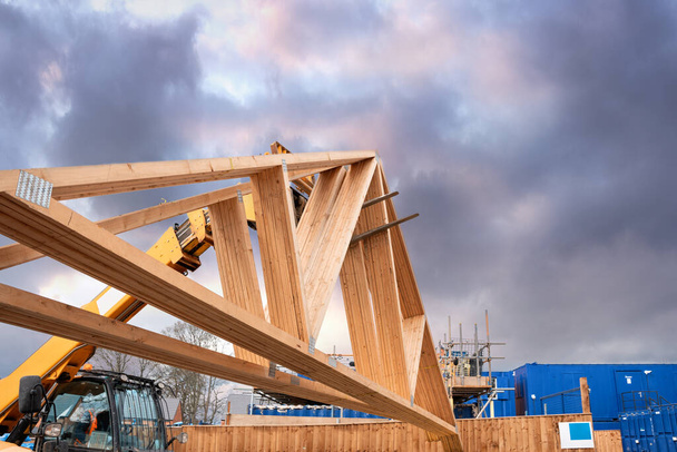 Heavy machinery shifting roof trusses on new residential housing development construction site - Photo, Image