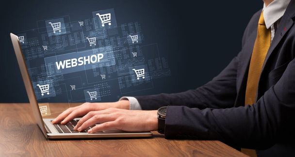 Businessman working on laptop with WEBSHOP inscription, online shopping concept - Fotó, kép