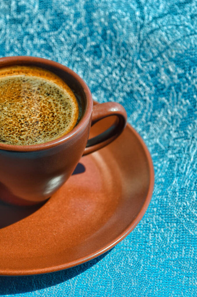 太陽の光の下でターコイズの背景に朝のエスプレッソコーヒーのカップ. - 写真・画像