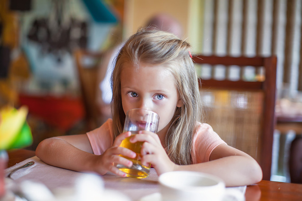 Adorable little girl having breakfast at resort restaurant outdoors - Фото, зображення