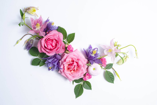 Feestelijke bloemenachtergrond. bloemen lay-out van roze en violette aquilegia op een witte achtergrond. Bovenaanzicht, vlak. Bloemen grens en kopieer ruimte.  - Foto, afbeelding