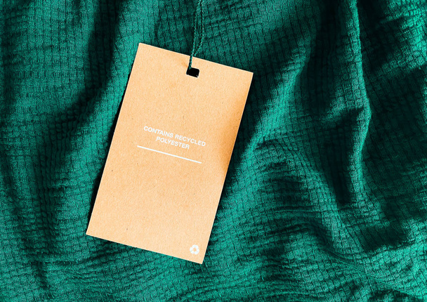 Содержит переработанные полиэфирные этикетки этикетки, ценовую карту на роскошный изумрудно-зеленый фон ткани, торговый и розничной концепции - Фото, изображение