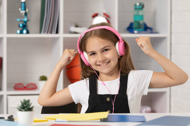 onnellinen lapsi kuunnella musiikkia kuulokkeet koulun luokkahuoneessa. onnellisuus. - Valokuva, kuva