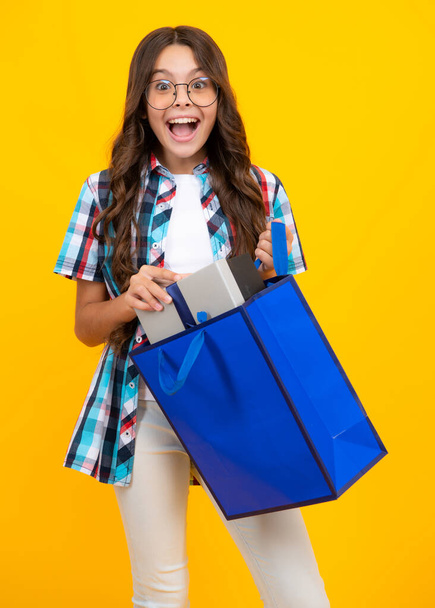 Amazed teen girl. Stylish teen girl with shopping sale bags. Kid holding purchases. Excited expression, cheerful and glad - Fotoğraf, Görsel