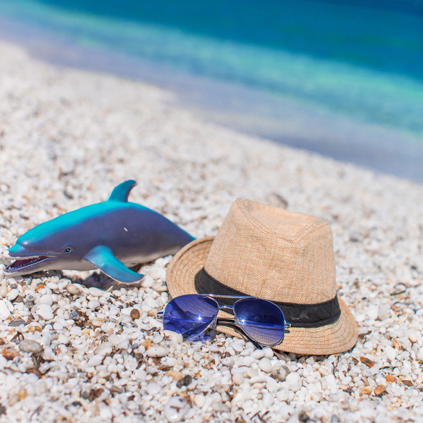 Zomer accessoires, zonnebril strand speelgoed en hoed op wit strand - Foto, afbeelding