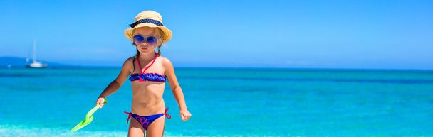 Petite fille s'amuser avec jouet de plage à la plage tropicale
 - Photo, image
