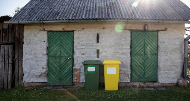 分別された廃棄物容器、緑と黄色。屋外、晴れた日. - 写真・画像