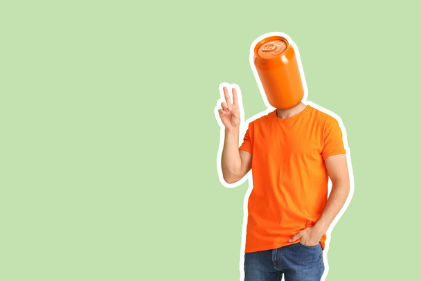 Hombre con lata de bebida en lugar de su cabeza mostrando gesto de victoria sobre fondo verde - Foto, imagen