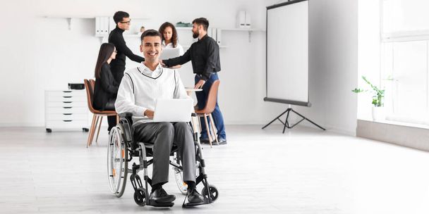 Ofisteki iş toplantısında tekerlekli sandalyedeki genç adam. - Fotoğraf, Görsel
