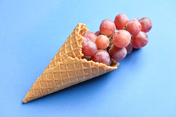 Вафельний конус зі свіжим виноградом на кольоровому фоні
 - Фото, зображення
