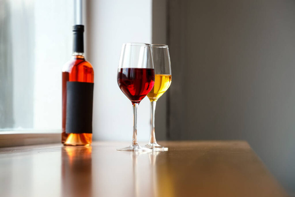 Sklenice z různých vín a lahví na stole - Fotografie, Obrázek