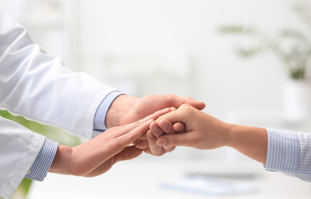 Doctor touching hand of patient in clinic - Foto, Bild