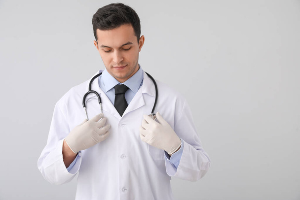 Médecin masculin avec stéthoscope sur fond gris
 - Photo, image