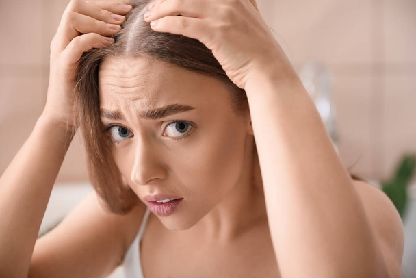 Mujer joven estresada con problemas de pérdida de cabello en casa - Foto, imagen