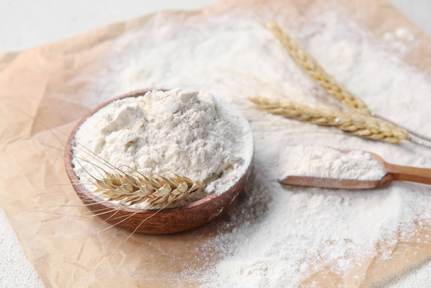 Cuenco con harina de trigo y cucharada en pergamino - Foto, Imagen