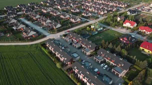Letecký bezpilotní pohled na evropskou příměstskou čtvrť s rodinnými domy, Rezidenční čtvrť s budovami a ulicemi při západu slunce v malém evropském městě - Záběry, video
