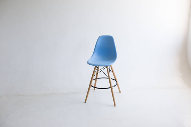 Kiev, Ukraine - June 10, 2019: Blue wooden chairs for the legs on a white background. White cyclorama in the studio. - Photo, image
