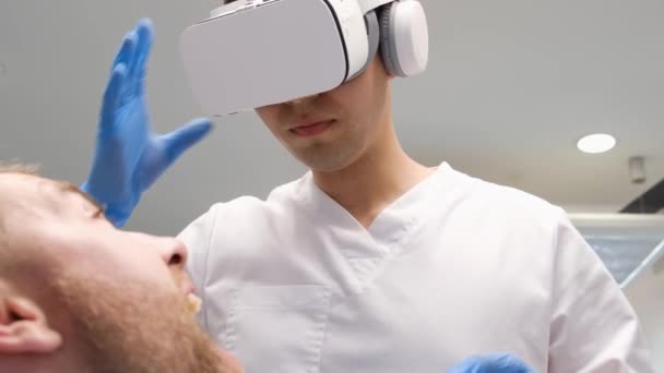 Een tandarts in 3D bril werkt met een klant in de kliniek van de toekomst. Virtuele realiteit behandeling. Tandheelkunde van de toekomst - Video