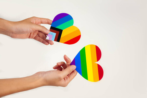 Gay pride concept. people holding gay pride LGBT rainbow paper cut heart on white background - Fotografie, Obrázek