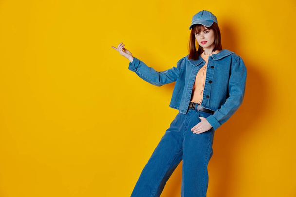 Beauty Fashion woman in a cap and denim jacket posing yellow background unaltered. High quality photo - Foto, Bild