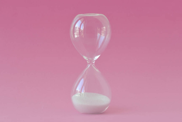 Hourglass on pink background - Concept of infertility and biological clock in women - Fotoğraf, Görsel