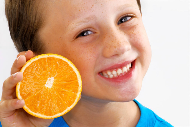 Happy kid holding an sliced orange fruit portrait. - Fotoğraf, Görsel