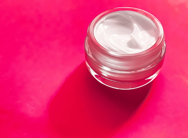 Crema facial hidratante tarro sobre vidrio y fondo rosa, producto de belleza y cuidado de la piel, concepto de ciencia cosmética - Foto, imagen