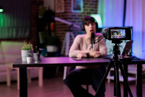 İçerik yaratıcısı stüdyodaki canlı yayın ekipmanlarını kullanarak kamera önünde yaşam tarzı podcast bölümünü kaydediyor. Kadın vlog kaydedicisi çevrimiçi talk show sohbet, web livestream. - Fotoğraf, Görsel