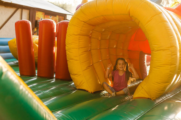 Un niño alegre juega en un castillo inflable. - Foto, Imagen