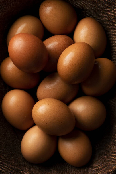 Red hen eggs on dark rustic table, organic food ingredients - Photo, Image