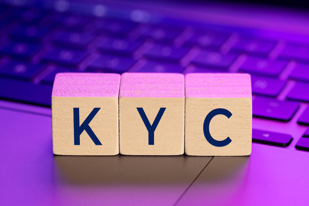 Palabra KYC en bloques de madera en el ordenador portátil con luces de colores. Conozca en línea su concepto de cliente - Foto, Imagen