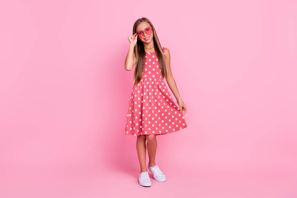 Full size photo of satisfied positive pupil hand touch glasses toothy smile isolated on pink color background. - 写真・画像