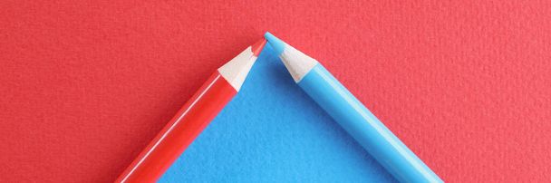 Gros plan des crayons bleus et rouges disposés en cadre triangulaire, diviser la surface en deux couleurs. Retour à l'école, art, créativité, design, exprimez-vous à travers le concept de dessin. Espace de copie - Photo, image