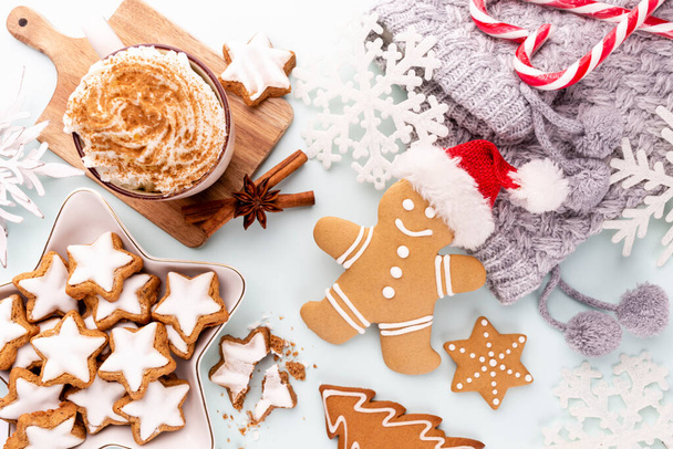 Tasty gingerbread cookies and Christmas decor on pastel background. - Foto, imagen