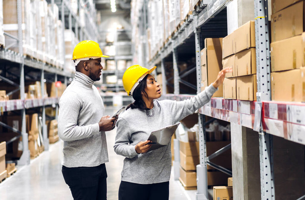 Portrait two african american engineer team shipping order detail on tablet check goods and supplies on shelves with goods inventory in factory warehouse.logistic industry and business export - Φωτογραφία, εικόνα