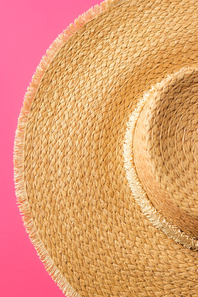 Літні предмети одягу. Вид зверху на соломинку, ізольований на рожевому тлі. Концепція літнього пляжного відпочинку. Пляжні модні аксесуари для жінок
. - Фото, зображення